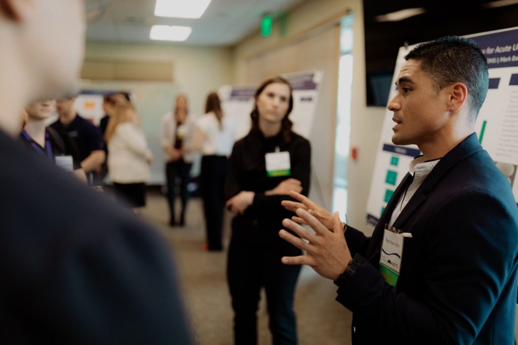 Students presenting posters at PNWU's 2024 Research Symposium